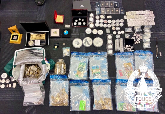 A large collection of coins and other currency laid out on a carpet.