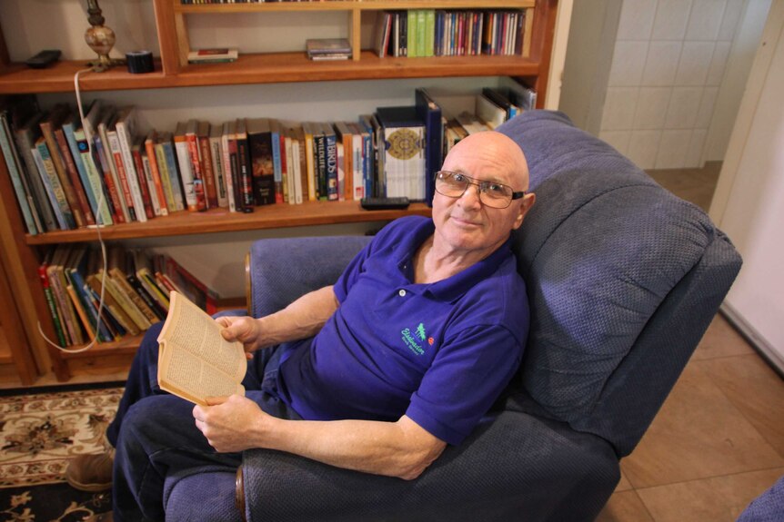 Alice Springs resident Markus Hartmann reads in his living room.