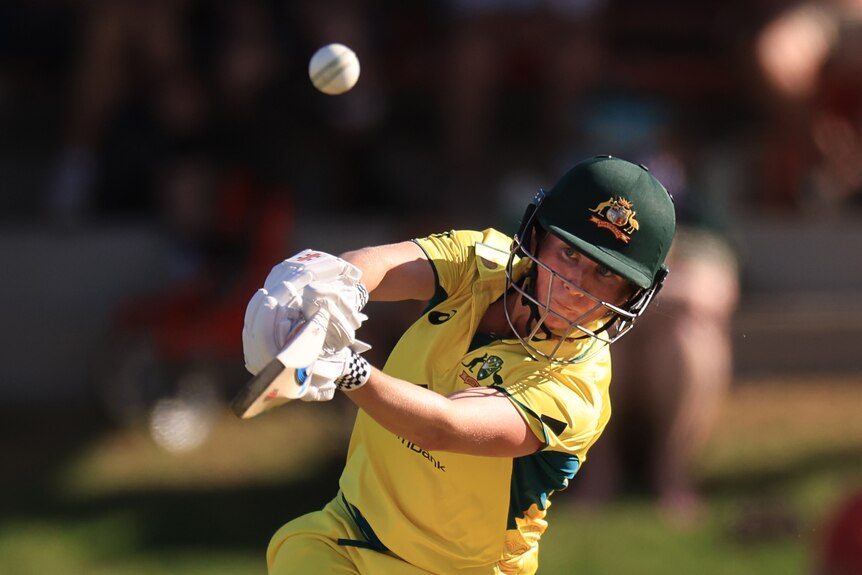 Beth Mooney drives a cricket ball during an ODI.