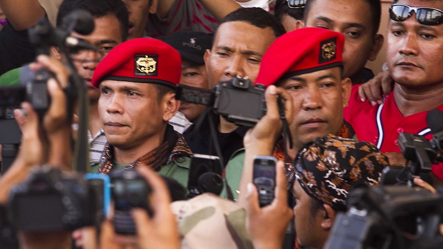 Ucok Tigor Simbolon and Sugeng Sumaryanto leave court after receiving their sentence.