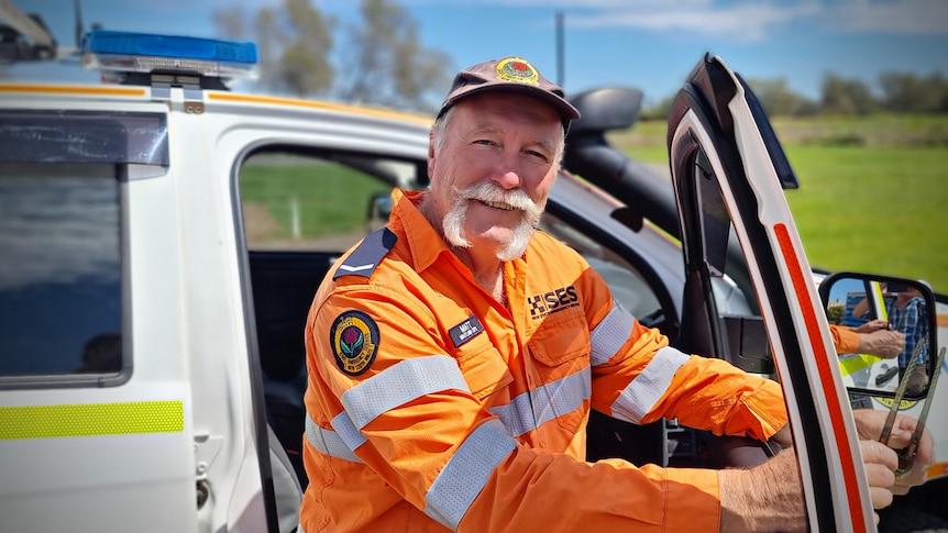 Man in hi-vis SES uniform getting out of a car.