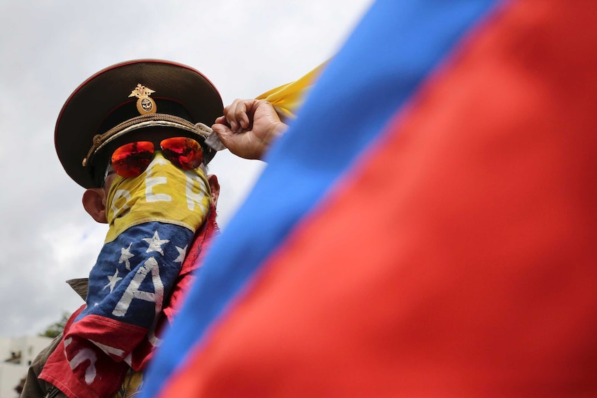 An anti-government demonstrator wearing a Russian military hat and a scarf around his face