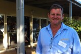 Chris, dressed in a blue, long sleeved, collared shirt, standing outside the Esperance bay yacht club