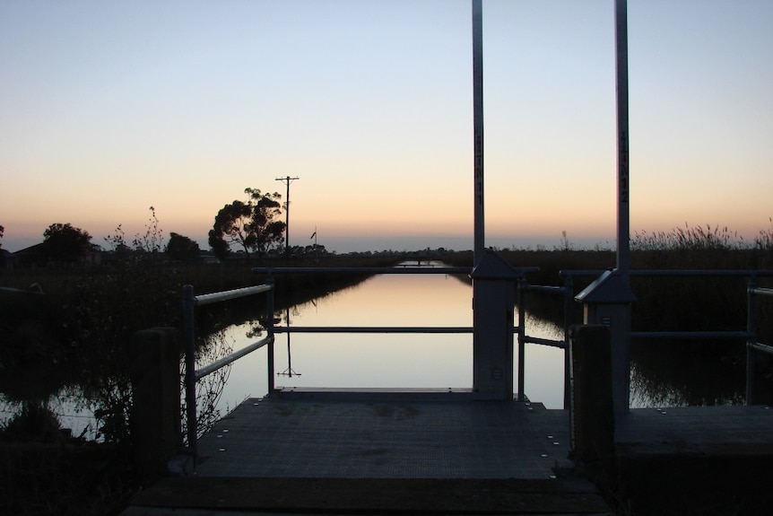 The sun sets over an irrigation channel