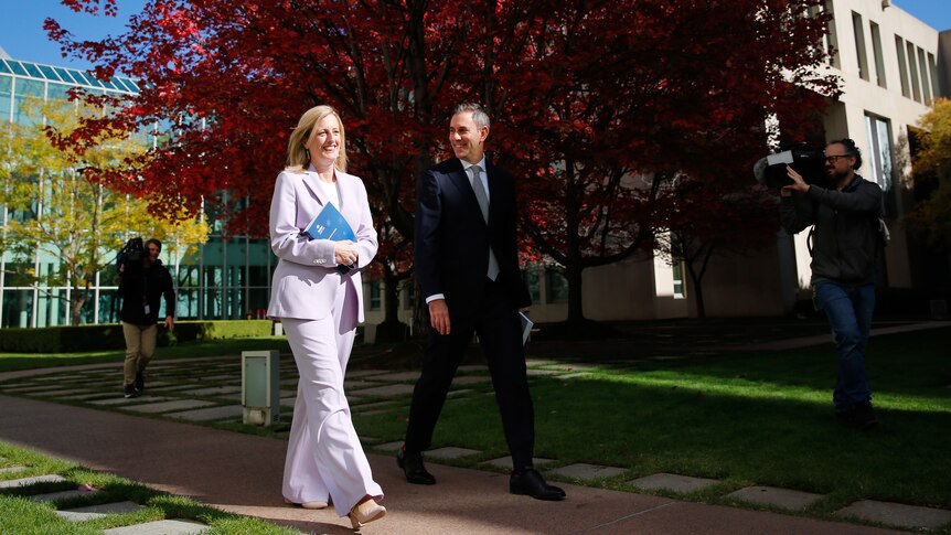 Katy Gallagher and Jim Chalmers walking past the budget tree