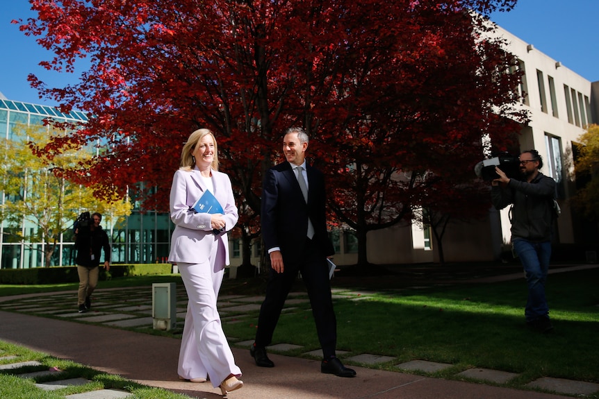 Katy Gallagher and Jim Chalmers walking past the budget tree