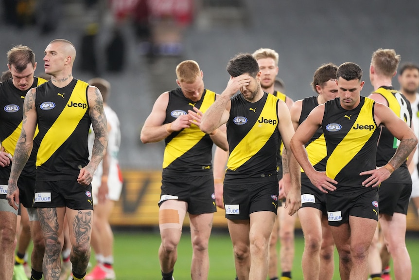 A group of Richmond AFL players walk off the MCG after losing to St Kilda.