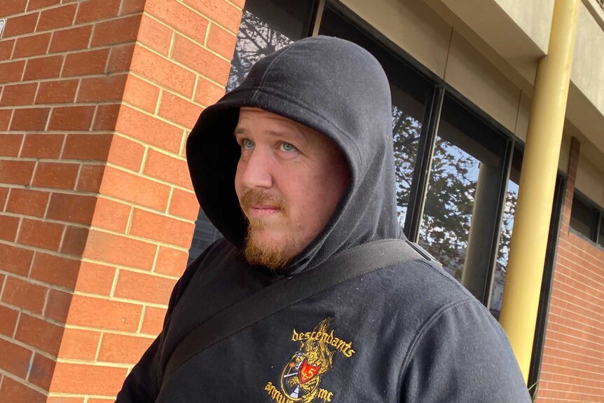 A man wearing a black hoodie with the word Descendants on it