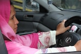 woman in traditional clothing driving car