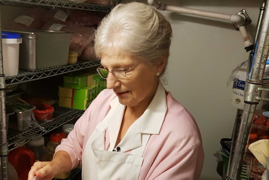 Jeanne Fraser looking at spoiled food in a cool room.