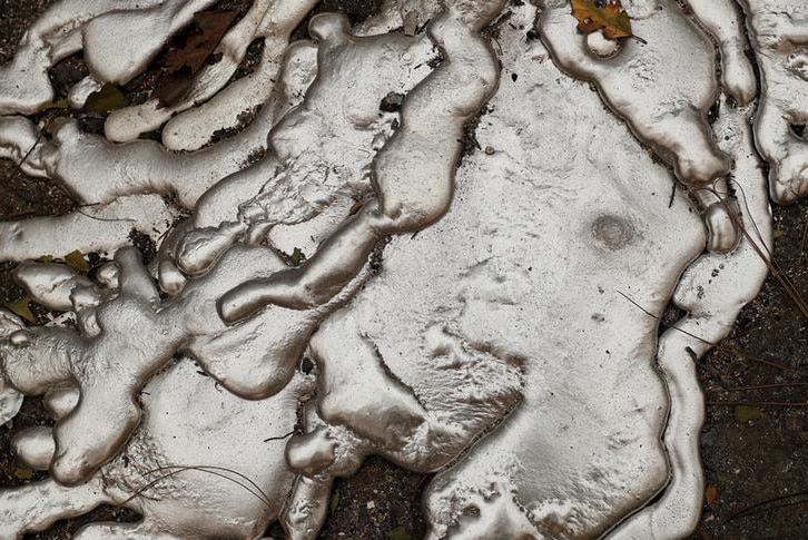 Melted metal from an abandoned car destroyed by wildfires in Paradise, California, drips along concrete