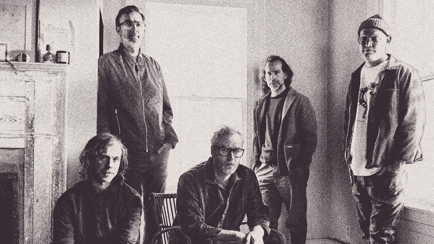 A black and white press shot of The National in a rustic lounge room