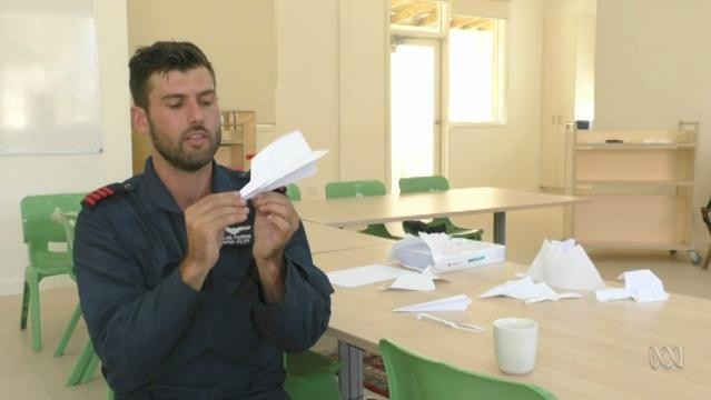 Man holds folded paper plane