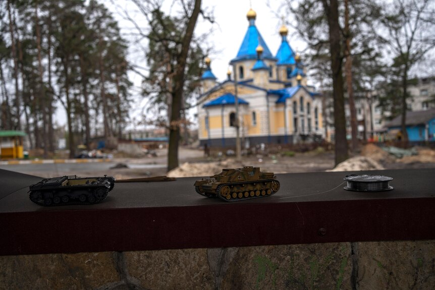 Toy tanks sit at the entrance of a summer camp in Bucha.