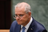 Scott Morrison looks serious, as he sits in the House of Representatives.