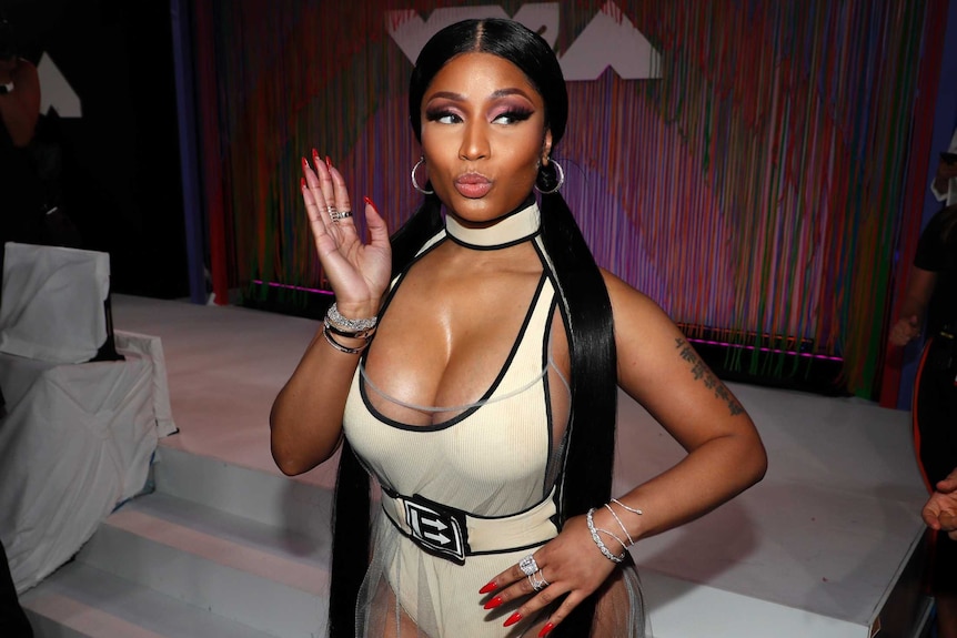 A close up of Nicki Minaj, who is making a sassy waving gesture.