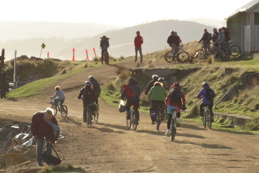 Tourists riding bikes on a dirt track