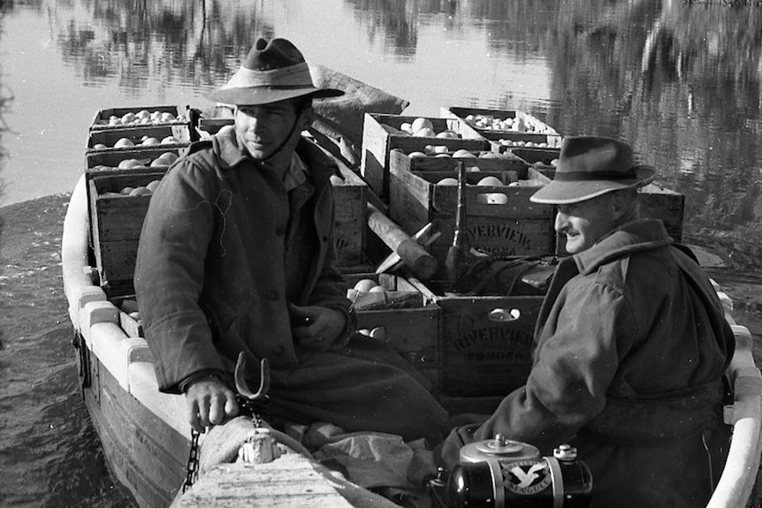Men in boat with oranges