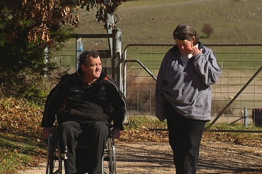 Sexual abuse survivor Jason Thorpe in a wheelchair and mother Deirdre Kinghorn walking along a path