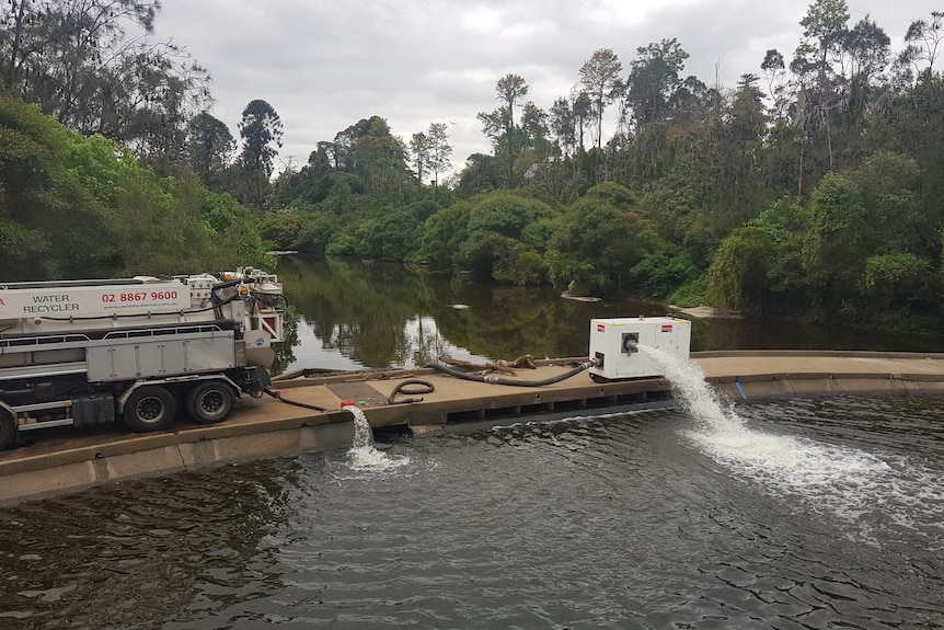 A truck pumps water into a river