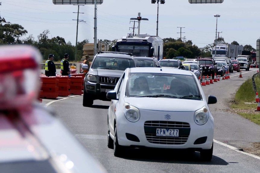 Cars line up at a police check point on the Princes Highway.