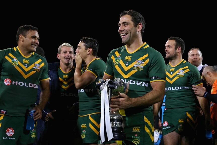 Time to celebrate ... Kangaroos captain Cameron Smith and team-mates enjoy a walk with the trophy.