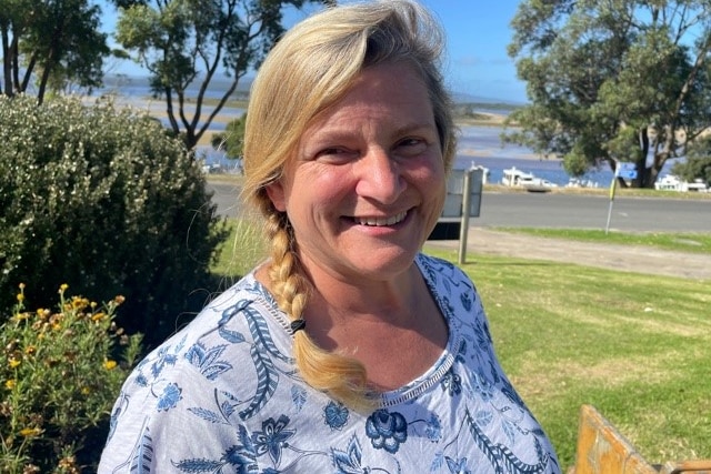 middle aged woman with a view of Mallacoota behind 