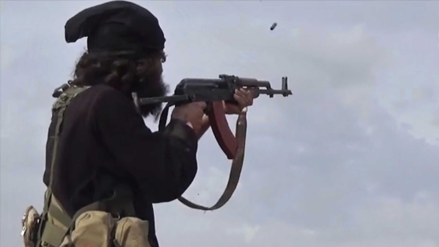 An IS fighter fires his weapon during clashes with the US-backed Syrian Democratic Forces.