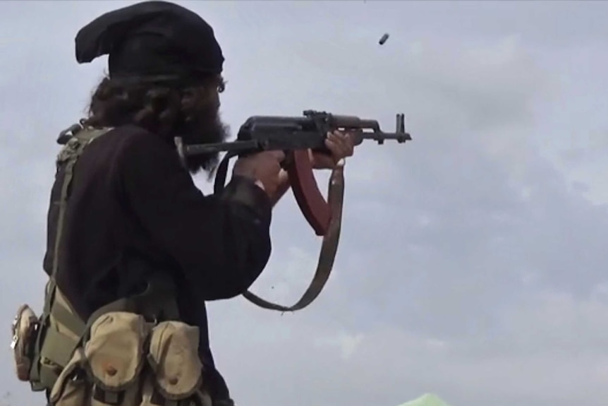 An IS fighter fires his weapon during clashes with the US-backed Syrian Democratic Forces.