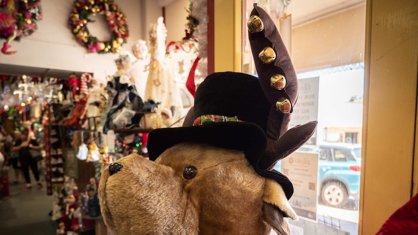 Large plush reindeer wearing suit and top hat