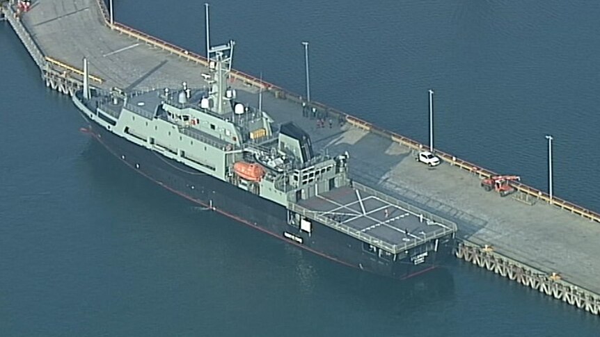 A Navy ship docked at a port in Hastings