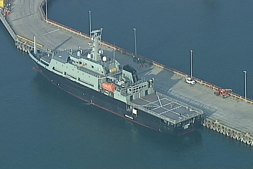 A Navy ship docked at a port in Hastings