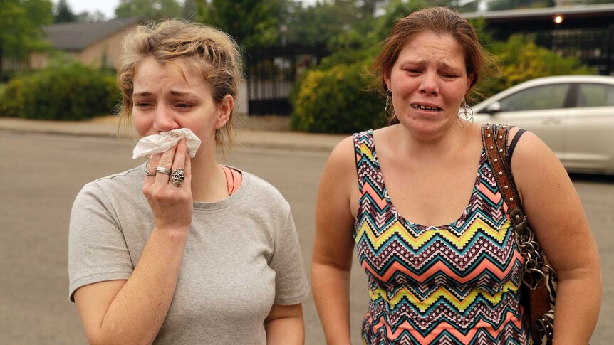 Sherry Bledsoe, left, cries next to her sister, Carla, outside of the sheriff's office