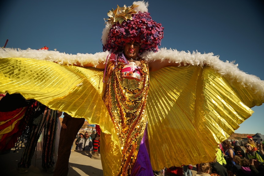 Man dressed in gold cape on stage