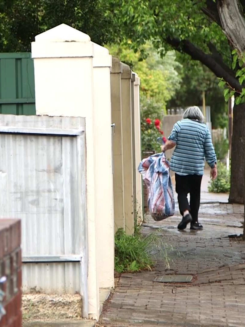 Joan walks around homes in her block, collecting bottles.