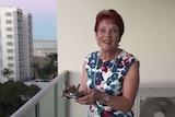 Pauline Hanson holds a drone remote controller with both hands and a big smile on her face.