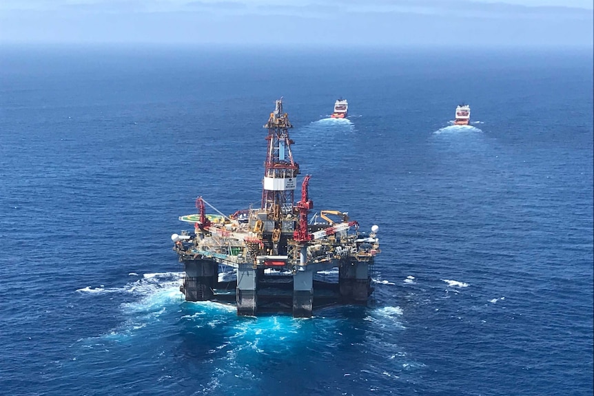 The 107-metre-long Ocean Monarch drilling rig being moved by tug boats.