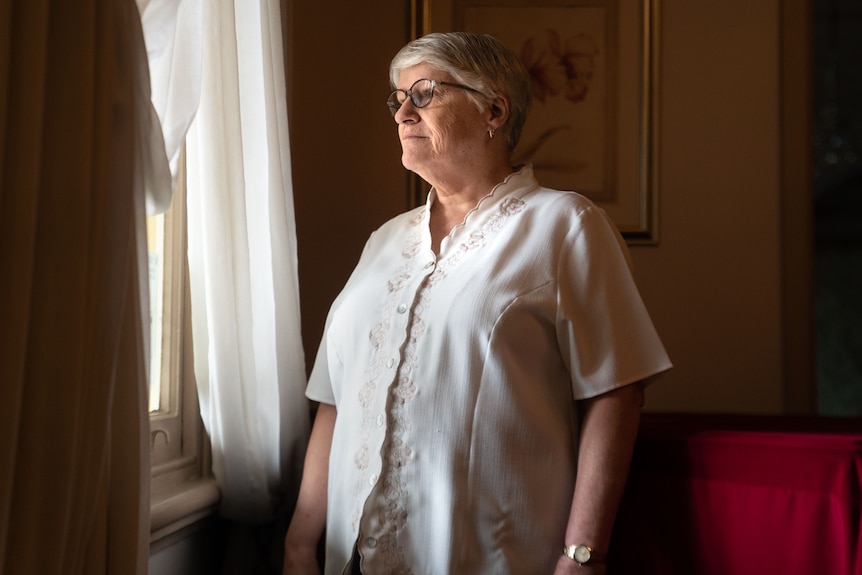 woman looks out a window