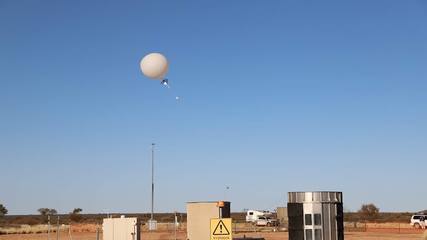 A hydrogen weather balloon is released at the Giles Weather Station.
