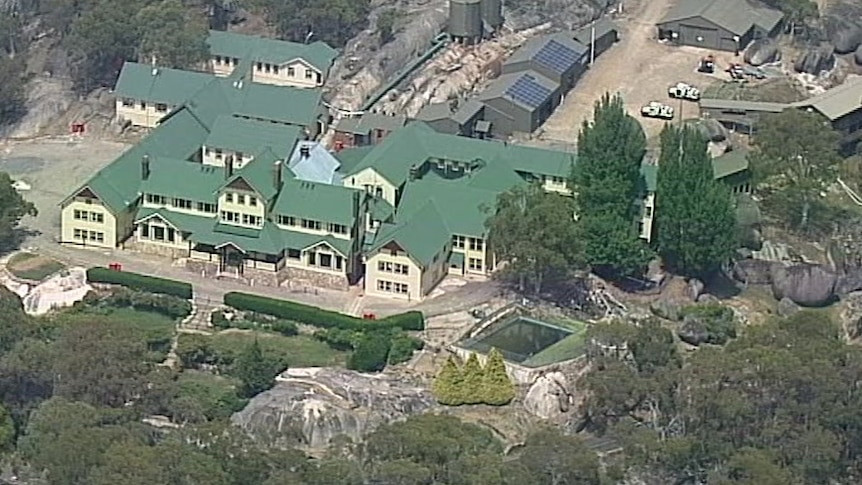 An aerial photo of the Mount Buffalo Chalet showing an older-style building with extensions and green roofing.