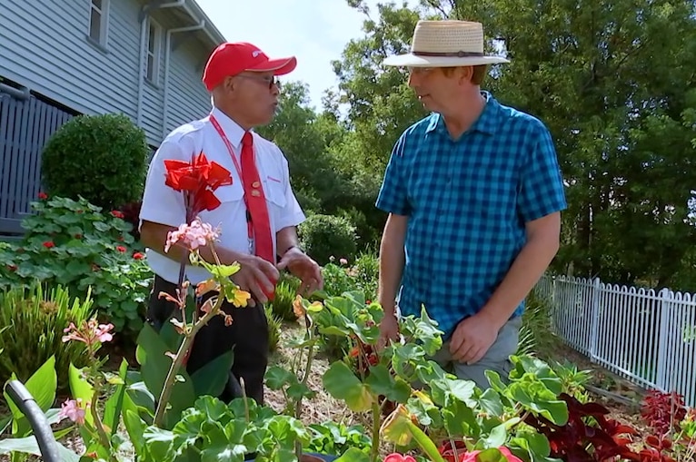 Queensland Rail stationmaster Anthony Vethecan and Gardening Australia's Jerry Coleby-Williams face each other in a garden