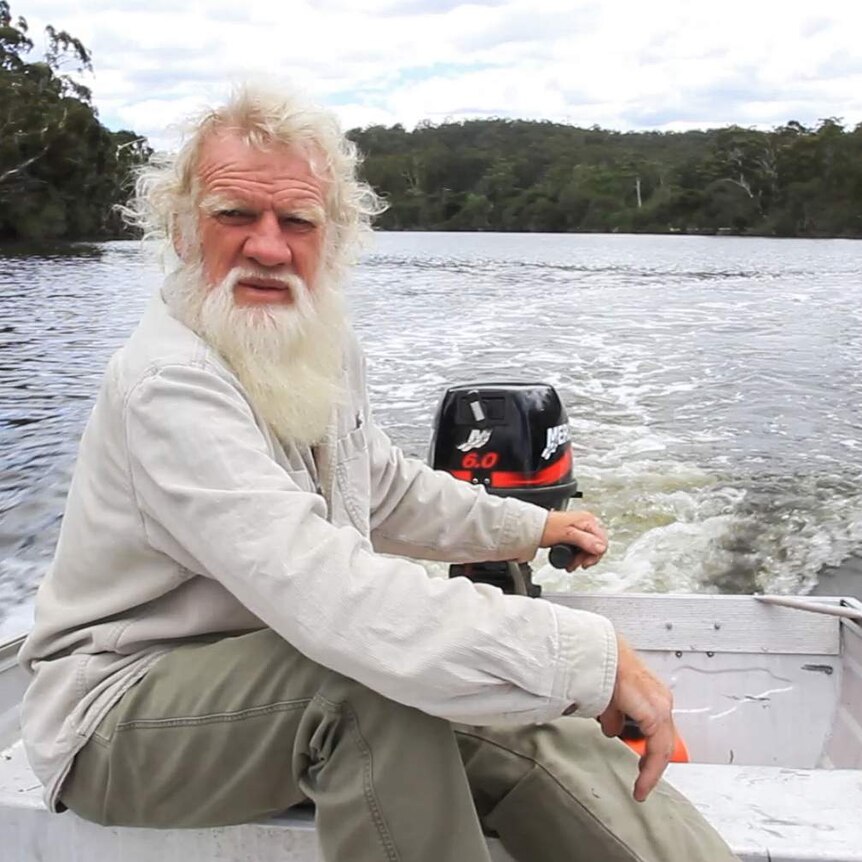 Bruce Pascoe at the helm of a small boat on the Wallagaraugh River