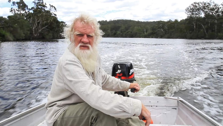 Bruce Pascoe at the helm of a small boat on the Wallagaraugh River