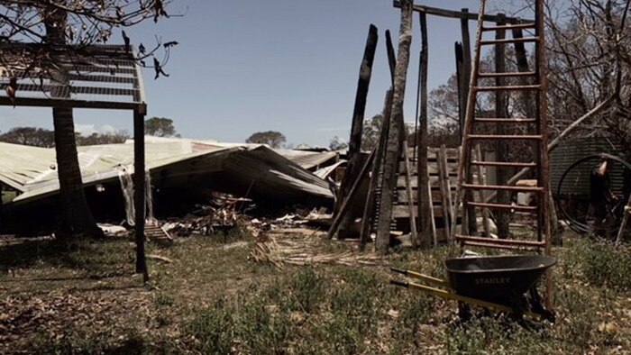 Damaged equipment and shed after a bushfire at apiarist George Spiteri's property at Deepwater.