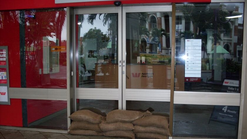 Sandbags piled in front of door of branch of a bank in Mackay.