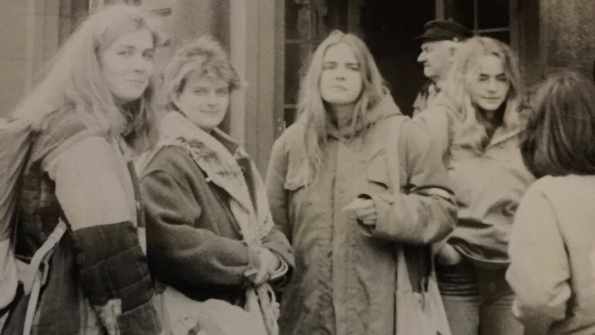 1987 black-and-white image of four East German women standing in front of sandstone building.