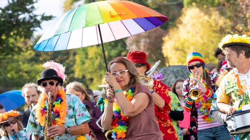 CresFest Parade features people playing music in bright colours and with rainbow umbrella 