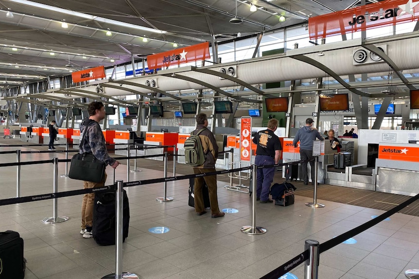 Photo of people lining up to check into a Jetstar flight at a safe social distance.