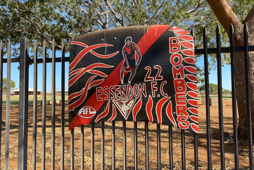 A car bonnet, hand-painted in Essendon's red and black colours, carries the image of a player and the number 22