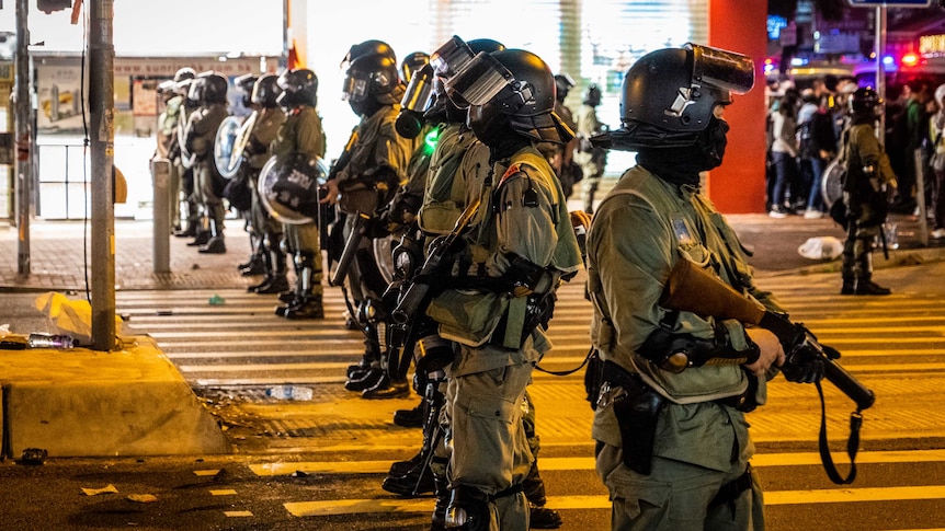 A row of riot police in Hong Kong at night